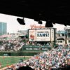 Crowd enjoying a baseball game at Wrigley Field, Chicago's iconic stadium, on a sunny day.