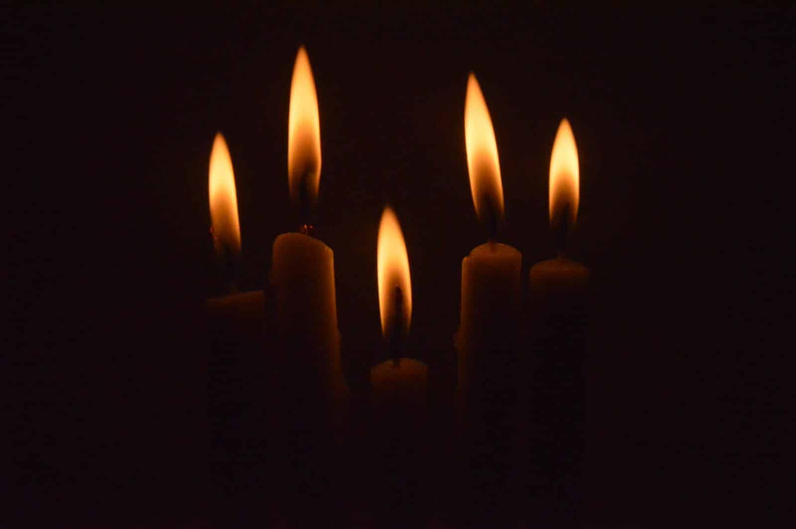 a group of lit candles in the dark