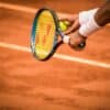 a person holding a tennis racket on a tennis court