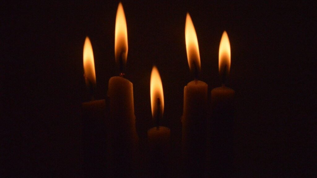 a group of lit candles in the dark