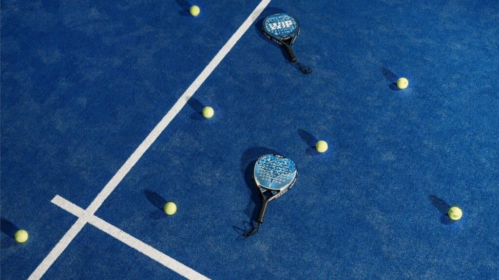 two tennis rackets and balls on a blue tennis court
