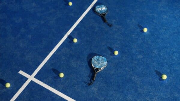 two tennis rackets and balls on a blue tennis court