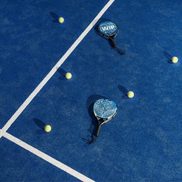 two tennis rackets and balls on a blue tennis court