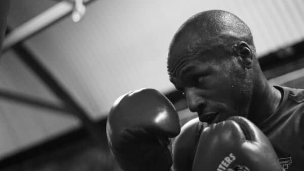 grayscale photo of man wearing boxing gloves