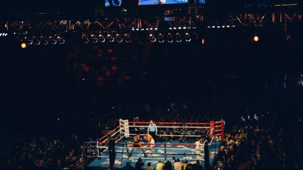Two boxers sparring in a ring at a crowded arena in Inglewood