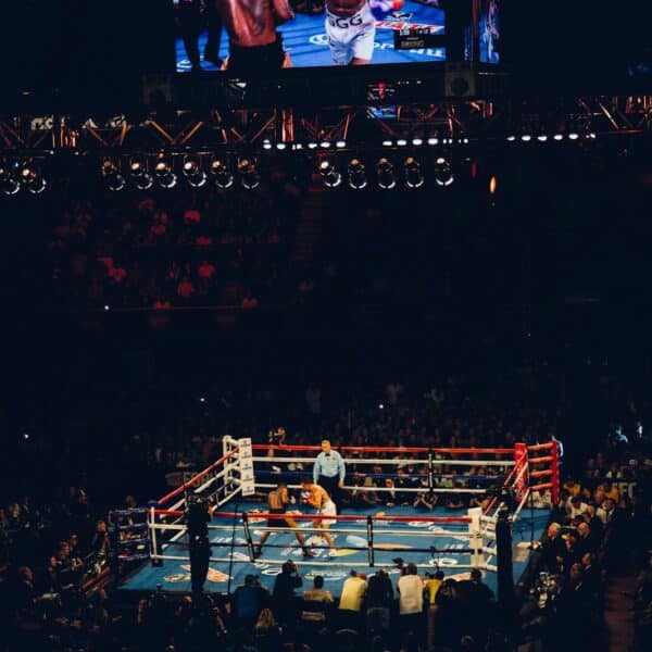 Two boxers sparring in a ring at a crowded arena in Inglewood
